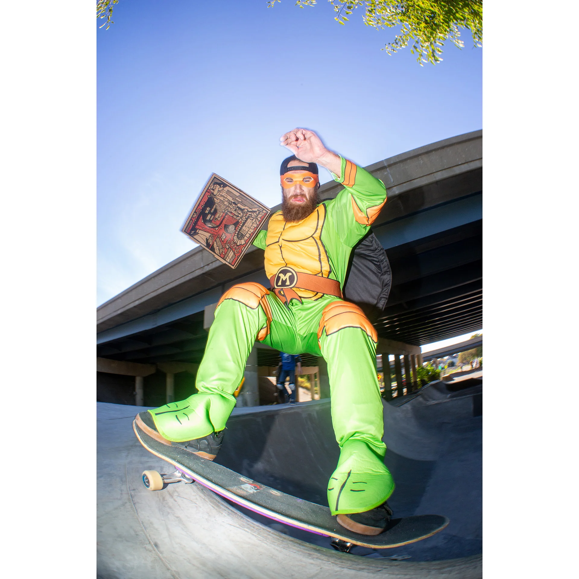 Photo of a beared man dressed as a Teenage Mutant Ninja Turtle grinding a new obstacle during a National DIY Halloween Skate Jam. Photo taken by Dylan Shanahan